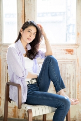 Ms. Yako Morima used to be a member of Takarazuka Revue and is currently a Japanese & Asian mature female fashion model & ballet coach, she is wearing a very light purple blouse, jeans, she is sitting, her height is 173 cm, she is tall, and her style is very good.