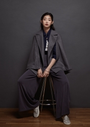 Ms. Anju Eoka was born in 1995 & she is 176 cm tall, she is a Japanese & Asian fashion model & catwalk model (runway model), this is a full-length photo of her tall girl, she is a tall & slender, she is dressed in dark gray and sits in a chair.