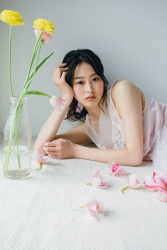 Ms. Sumiri is a tall Japanese & Asian fashion model, her height is 171 cm and there are multiple flowers beside her, she is wearing a pink dress, her style is very good.