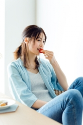 This is Ms. Sumiri Kurauchi, a Japanese & Asian fashion model wearing blue clothes & jeans, she is eating strawberry, her height is 171 cm and she is tall, her style is very good.