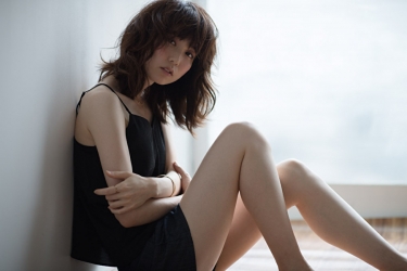 Ms. Hinaka Tsurukubo is photographed from the side wearing a black camisole and black shorts, she is sitting on the floor grasping her knees, she is a Japanese & Asian mature beauty fashion model, her height is 171 cm, and her figure is very pretty.