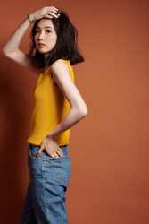 Ms. Hinaka is wearing a yellow short-sleeved shirt and jeans, she is standing, she is a Japanese & Asian mature female fashion model, her height is 171 cm, her figure is very pretty.