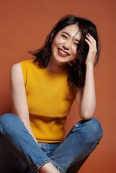 Ms. Hinaka Tsurukubo is wearing a yellow short-sleeved shirt and jeans, she is sitting, she is a Japanese & Asian mature female fashion model, her height is 171 cm, her figure is very pretty.