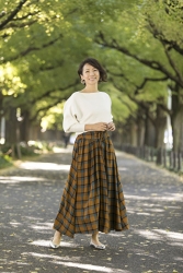 Ms. Tamaki Katsuragi is a mature Japanese & Asian fashion model, wearing a white long-sleeved blouse, dark yellow skirt, and she's standing on the sidewalk.