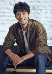 Mr. Hiroaki Kyusogami is wearing a mixed color of green jacket, white T-shirt, jeans, he is sitting, he is a handsome Japanese (Asian) actor, fashion model.