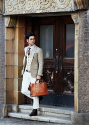 Mr. Hiroaki Kyusogami, wearing a beige suit and carrying a brown business bag, is about to leave the gate, he is a handsome Japanese (Asian) actor, fashion model.