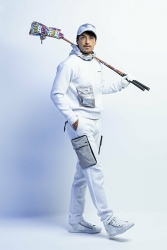 Mr. Rodrigue Takise is wearing white clothes and holding golf clubs, he is a half Japanese half French handsome mixed-race male model.