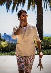 Mr. Rodrigue Takise is wearing a beige jacket and shorts, he has a mobile phone in his hand and is calling, he is a half Japanese half French handsome mixed-race male model.