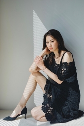 Ms. Sumiri Kurauchi is a tall Japanese & Asian fashion model, her height is 171 cm and she is tall, she is sitting on the floor grasping her knees, she is wearing a black dress and her style is very good.