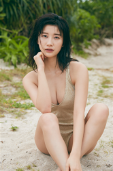 Ms. Ayuu Koichi wears a beige swimsuit, she is sitting on the sandy beach, she is a beautiful Japanese & Asian big breasts TV personality, bikini model (gravure idol, swimwear model), actress.