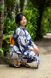 Ms. Serika Fukushi is wearing a blue yukata (with a floral pattern), she is squatting, she is a Japanese & Asian beautiful and sexy fashion model, gravure idol (bikini model, swimwear model, pin-up model) freelance announcer, TV personality, pharmacist, her bust is 87 cm, She has attractive big breasts and beautiful breasts, and she is a woman with sexual charm.
