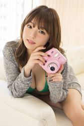 Ms. Aika Shinoba has big breasts, the cute Japanese & Asian gravure idol (swimsuit model) Ms. Aika Shinoba has a pink camera in her hands, she is a sexually attractive woman, she is dressed in gray and is wearing a green bikini.