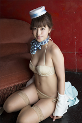 Ms. Arian took off her beautiful lady's suit and showed off her beige bikini swimsuit, she sits on the black floor, she is a beautiful & cute Japanese & Asian gravure idol (swimwear model, pin-up model), actress, TV personality.