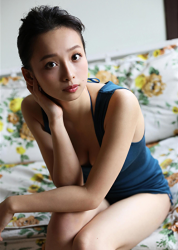 Ms. Asui Hananoi is wearing a blue shirt, sitting on the sofa (floral pattern), she is a Japanese & Asian beautiful cute young slim fashion model, bikini model (gravure idol, pin-up model, swimwear model), actress, TV personality, her figure is very charming.
