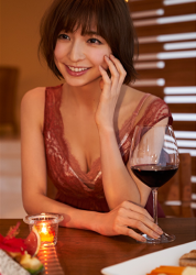 Ms. Himari Sasakabe is a beautiful, elegant and mature Japanese & Asian fashion model, TV personality, actress in a red dress, she is in her 30s and she used to be an idol singer, there is red wine on the desk and she is sitting.