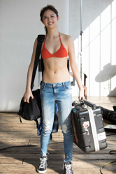Ms. Ruika Kumakori wears jeans, orange bra and holds a black suitcase and big black bag in her hand, she is a tall and slender Japanese & Asian beauty fashion beauty model, photography idol, TV personality, pit babe (paddock girl, grid girl), her figure is very slender and attractive.
