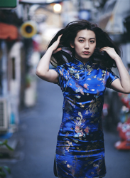 Ms. Aisui Saito is wearing a blue cheongsam, she is walking on the road, she is a beautiful and sexy Japanese & Asian gravure idol (bikini model, swimsuit model, pin-up girl), actress, her bust is 85 cm, she has beautiful breasts, she is a woman with sexual charm.
