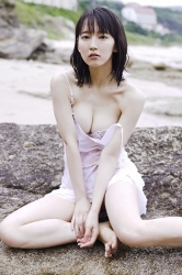 Ms. Rihoko Yoshikoshi is wearing a white slip, white bikini swimsuit, she is sitting on a shore, she is a beautiful and elegant Japanese & Asian actress, gravure idol (bikini model, swimwear model, pin-up model), she has charming beautiful breasts.
