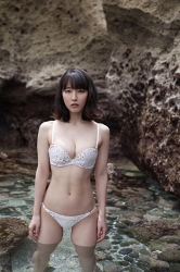 Ms. Rihoko Yoshikoshi is wearing a white bikini swimsuit, she is immersed in the sea of the shore, she is standing and her lower body is submerged in sea water, she is a beautiful and elegant Japanese & Asian actress and gravure idol (bikini model, swimwear model, pin-up model), she has charming beautiful breasts.