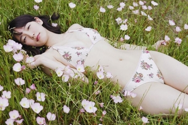 Ms. Rihoko Yoshikoshi is wearing white lingerie (with a floral pattern), she is lying on the grass, she is a beautiful and elegant Japanese & Asian actress and swimsuit model, she has charming beautiful breasts.