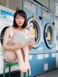 Ms. Rihoko Yoshikoshi is wearing a white short-sleeved shirt, she's in the laundromat, she is sitting in a green chair and reading a book, she is a beautiful Japanese & Asian actress and gravure idol (bikini model, swimwear model, pin-up model) with charming beautiful breasts.