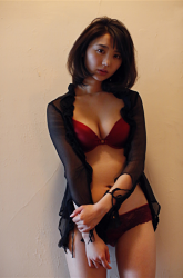 Ms. Nonomi Oie is wearing (translucent) black cardigan & red underwear, she is standing, she is a Japanese & Asian fashion female model, TV entertainer, she used to be a gravure idol (bikini model, swimwear model), her bust is 83cm, she has beautiful breasts.