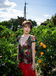 Ms. Sarara Oshinari is wearing (with floral pattern) green shirt, red skirt, she is standing in the tangerine field, she is a beautiful and sexy Japanese & Asian flat gravure idol (pin-up girl, bikini model), actress, her bust is 92cm, she has big breasts, beautiful breasts, she is a sexually attractive woman.