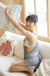 Ms. Asui Hananoi is wearing gray shirt, she is crouching on the white sofa with a pillow, she is a Japanese & Asian fashion model, bikini model (gravure idol, pin-up model, swimwear model), actress, and TV personality who is beautiful and slim, her figure is very charming.