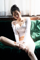 Ms. Hitoha Korekiyo is sitting on the green sofa in white lingerie, her height is 173 cm, she is tall, she is a tall fashion model, TV personality, actress, her bust is 84 cm, she has a beautiful breast.