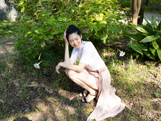 Ms. Hitoha Korekiyo is squatting in the field, wearing a white shirt, pink skirt, her height is 173 cm, she is tall, she is a tall fashion model, TV personality, actress, her bust is 84 cm, she has beautiful breasts.
