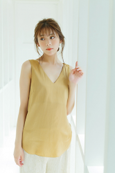 Ms. Naasu Takamichi is a young Japanese & Asian fashion model and actress wearing a tawny shirt and beige pants, she is standing by the window.