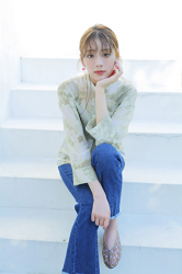 Ms. Naasu Takamichi is a young Japanese & Asian fashion model and actress wearing a yellow-green blouse and jeans, she is sitting on the white stairs.