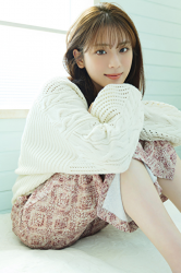 Ms. Naasu Takamichi wears white sweater, brown camisole, red trousers of young Japanese & Asian fashion model and actress, she is sitting on the floor grasping her knees.