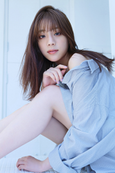 Ms. Naasu Takamichi is a young Japanese & Asian fashion model and actress wearing a light blue blouse, she is sitting on the floor grasping her knees.