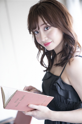 Ms. Ayaka is wearing a black dress, she is a beautiful & cute Japanese & Asian model, freelance announcer, TV personality, she holds a pink book in her hand.