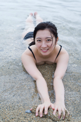 Ms. Kirara Takazuma wears a black bikini swimsuit, she lies face down on the beach, she used to be an idol singer, she is a sweet and cute Japanese & Asian gravure idol (bikini model, swimsuit model pin-up girl) and actress.
