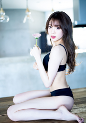 Ms. Yuina is wearing black underwear and holding flowers, she is sitting on the desk, she is a Japanese & Asian fashion model, actress and swimwear model (gravure idol, bikini model).