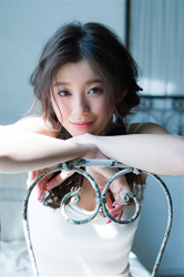 Ms. Ayami Asashige is wearing a white camisole and sitting on the bed, she is a beautiful and elegant Japanese & Asian tall fashion model, gravure idol (bikini model, swimwear model, pin-up model), TV personality, and actress.