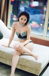 Ms. Karena Takeoka is wearing a dark green bikini swimsuit and sitting on the bed, she is a cute and elegant Japanese actress (Asian actress), bikini model (gravure idol, swimsuit model, pin-up model), fashion model.
