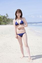 Ms. Maaya Iune is standing on the beach wearing a blue bikini swimsuit, she is a beautiful and cute Japanese & Asian gravure idol (bikini model, swimwear model, pin-up girl), TV personality, she has beautiful breasts.