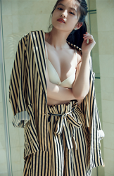 Ms. Mioka Imawatari is wearing black and gold vertical stripes dress and white bra, she is standing in the room, she is a beautiful and cute Japanese actress (Asian actress), gravure idol (bikini model, swimwear model, pin-up model), TV personality, her bust is 86cm and she has beautiful breasts.