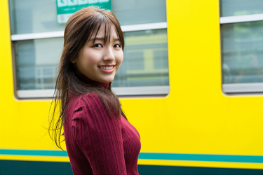Ms. Nanane Oka is waiting for the train, she wears a red short-sleeved blouse, and it seems that a yellow train has arrived, she is a beautiful and lovely Japanese & Asian gravure idol and actress.