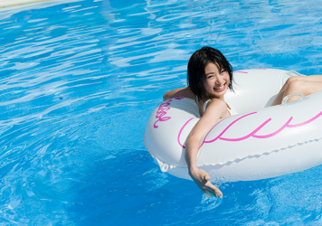 Ms. Natsuyo Ikekatsu wears a white bikini swimsuit, she wears a lifebuoy and floats on the pool, she is a Japanese & Asian beautiful and cute model & actress.
