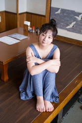 Ms. Kirara Takazuma is a very cute gravure idol (bikini model, swimsuit model, pin-up model) , actress, she is sitting on the floor grasping her knees in a Japanese-style house, she used to sing as an idol.