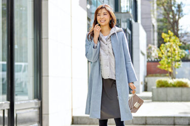 Ms. Akie Shibukawa is a beautiful Japanese & Asian fashion model, wearing a light blue coat and a gray skirt, she stands in a certain town.