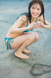 Ms. Emina Iori is a Japanese and Asian gravure idol (swimwear model, bikini model, pin-up girl), TV personality and singer, she is wearing a blue bikini and squatting on the beach.