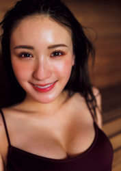 Ms. Emina Iori is a Japanese and Asian gravure idol (swimwear model, bikini model, pin-up girl), TV personality and singer, she is in a sauna room, she is wearing a purple bathing suit, sitting, and her face is emphasized.