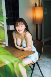 Ms. Emina Iori is a Japanese and Asian gravure idol (swimwear model, bikini model, pin-up girl), TV personality and singer, she is wearing a light blue dress and is sitting on a chair.