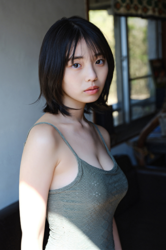 Ms. Kiira Kikuoki is a Japanese & Asian gravure idol (swimwear model, bikini model, pin-up model) and actress, she is wearing a green swimsuit and is standing, but her face is emphasized in the photo.