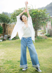Ms. Mariho is a Japanese & Asian fashion model, swimsuit model (gravure idol), actress, and former idol, she is wearing a white shirt and light gray running shirt and jeans, standing in the garden.
